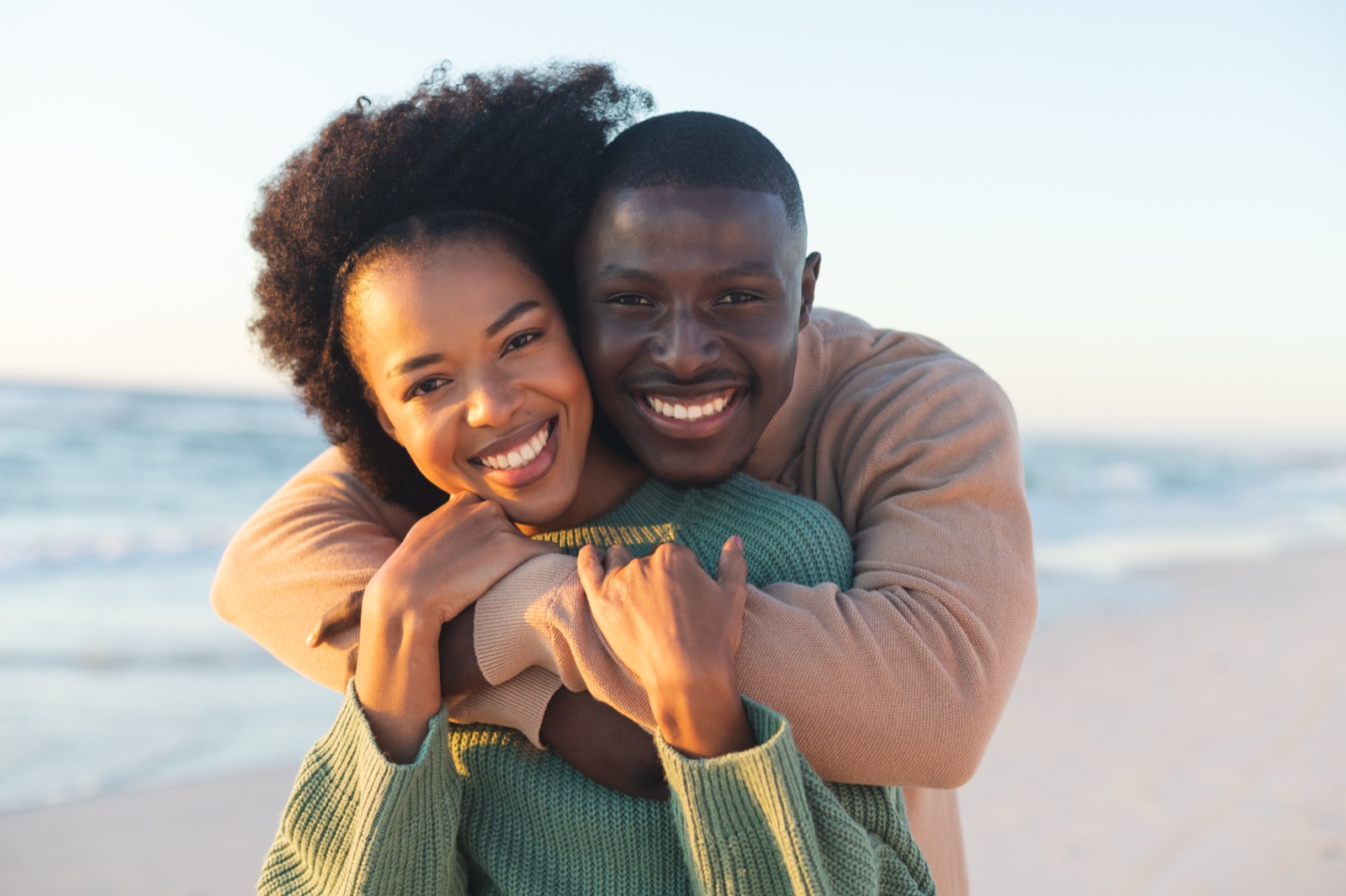 A couple embracing at golden hour, smiling